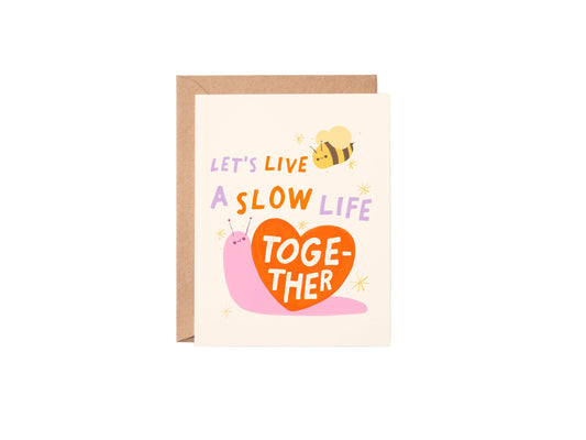 Greeting card with a snail, bee, and heart design on a white background