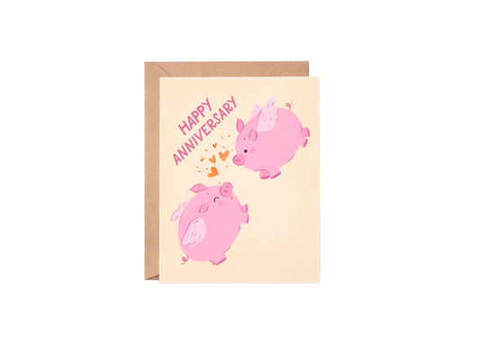 Greeting card with pink pigs and 'Happy Anniversary' text on a beige background